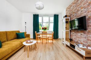a living room with a couch and a table at Happy Stay Apartments Osiek in Gdańsk