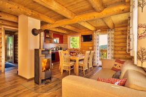 a living room with a fireplace and a table with a couch at Chalet Blumental in Neuschönau