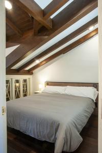 1 dormitorio con cama blanca y techo de madera en Aticos La Riba, en Luanco