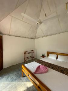 1 dormitorio con 2 camas y techo en Ubay Guest House, en Trincomalee