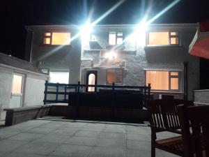 a house with lights on the side of it at night at Anglesey home by the sea in Amlwch