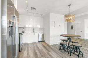 a white kitchen with a table and stools in it at Luxury 4 bedroom condo - Short Walk to Bourbon Street in New Orleans