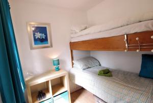 a small bedroom with two bunk beds and a table at 4 Laigh Isle in Isle of Whithorn
