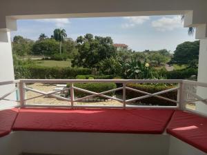 a balcony with a view of a garden at Tropical Optimal Tropicana Sur in Sosúa