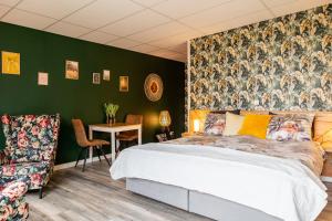 a bedroom with a bed and a green wall at Het Gelders Buitenleven in Overasselt