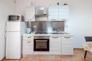 a kitchen with a white refrigerator and a sink at Casa Del Corso in Motta Camastra