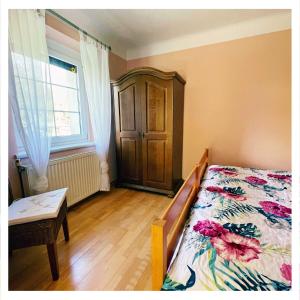 a bedroom with a bed and a dresser and a window at Ingrid’s Guesthouse Spittal in Spittal an der Drau