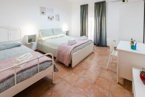 a bedroom with two beds and a table at Casa Del Corso in Motta Camastra