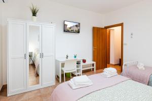 ein weißes Zimmer mit 2 Betten und einem Tisch in der Unterkunft Casa Del Corso in Motta Camastra