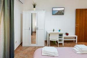 Habitación con cama y mesa con espejo. en Casa Del Corso en Motta Camastra