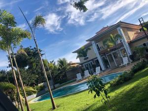 una casa con piscina y palmeras en Mansión Carmel, Luxo e Tranquilidade, Búzios/RJ, en Búzios