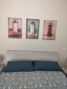 1 dormitorio con 3 pinturas en la pared sobre una cama en appartamento incantevole a due passi dal mare a Viserbella vicino fiera Rimini en Rímini
