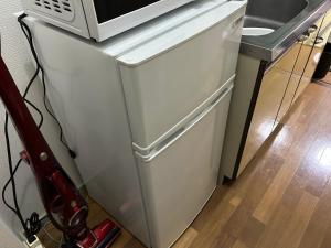 a white refrigerator with a microwave on top of it at Guest House Nishijin INN in Fukuoka +14 photos
