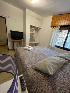 a bedroom with a bed with a remote control on it at POSADA DEL CENTRO in Villa General Belgrano