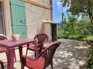 een paarse tafel en stoelen op een patio bij Logement entier et calme 55m2 avec SPA - sauna et borne de recharge 7KW in Meyreuil