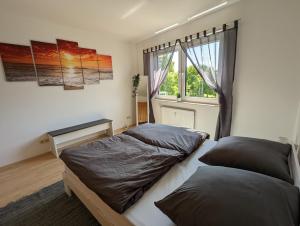 1 dormitorio con 2 camas y ventana en Feldberg Appartement, en Neu-Anspach