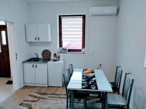 a kitchen with a table and chairs and a kitchen with a sink at Apartment Kraljevac in Visoko