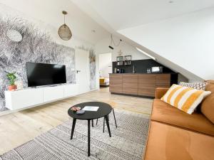 a living room with a couch and a tv at Bij het bos Texel in De Koog