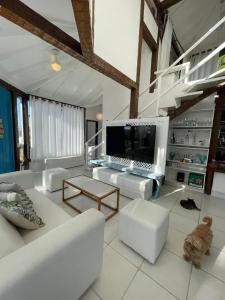 sala de estar con muebles blancos y TV de pantalla grande. en Casa Delfi, Hermosa vista, Jacuzzi e Praia , Buzios, en Búzios 37 fotos más
