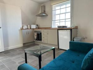 un soggiorno con divano blu e tavolo di 1 Bed Central Newark Flat 2nd Floor a Newark upon Trent