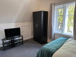 a bedroom with a black cabinet and a tv at 1 Bed Central Newark Flat 2nd Floor in Newark upon Trent