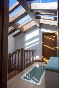 a glass floor in a room with a ceiling with beams at Aticos La Riba in Luanco