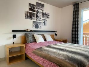 ein Schlafzimmer mit einem Bett mit zwei Kissen und Bildern an der Wand in der Unterkunft Cornelia in Saas-Fee