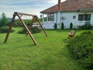 a swing set in a yard in front of a house at Apartmani Ćosić in Kuršumlija