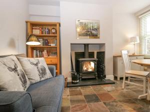 a living room with a couch and a fireplace at Meadowbank Cottage in Carnforth