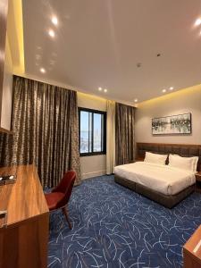 Habitación de hotel con cama y escritorio en نمار هوم للاجنحة المخدومة -طويق en Riad
