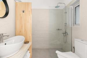 a bathroom with a white sink and a shower at Penelope Village in Kalo Livadi