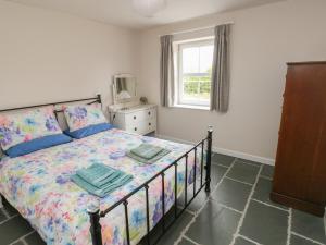 a bedroom with a bed and a window at Ystabl Robyn in Carmarthen