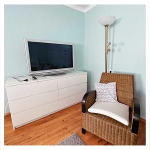 sala de estar con TV y silla en Ingrid’s Guesthouse Spittal en Spittal an der Drau