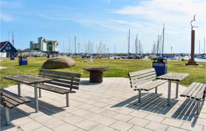 tres bancos y una mesa de picnic en un parque cerca de un puerto en Amazing Apartment In Ystad With 1 Bedrooms, en Ystad