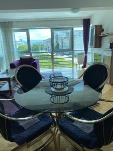 sala de estar con mesa de cristal y sillas en Apartment Deluxe Otoka, en Sarajevo