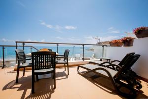 einen Balkon mit einem Tisch, Stühlen und Meerblick in der Unterkunft Apartments La Caleta Sunrises in Adeje