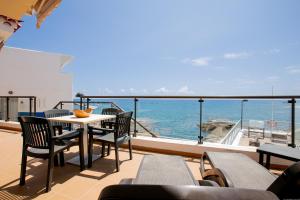 a balcony with a table and chairs and the ocean at Apartments La Caleta Sunrises in Adeje