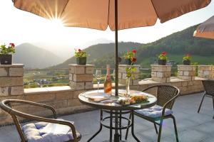 uma mesa e cadeiras numa varanda com um guarda-sol em Villa Bello em Berchtesgaden