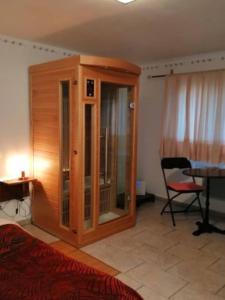 - une chambre avec une armoire en bois, une table et une chaise dans l'établissement Mont Blanc - locations de charme, à Beaurainville