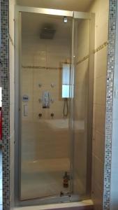 La salle de bains est pourvue d'une douche avec une porte en verre. dans l'établissement Mont Blanc - locations de charme, à Beaurainville