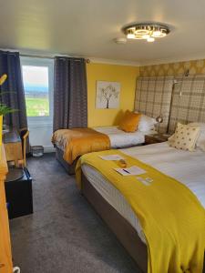 a hotel room with two beds and a window at Scooniehill Farm House B&B in St. Andrews