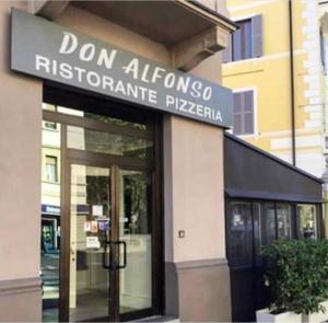 un bâtiment avec un panneau indiquant la pizzeria don albuquerque dans l'établissement Rooms Don Alfonso, à Parme