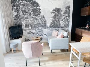 a living room with a couch and a tv at Bij het bos Texel in De Koog