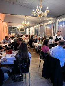 un groupe de personnes assises à table dans un restaurant dans l'établissement Rooms Don Alfonso, à Parme