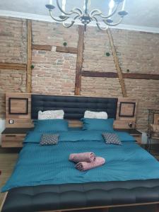 ein großes Bett mit blauer Bettwäsche und Kissen darauf in der Unterkunft VintageTrib in Sibiu
