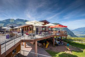 a building with tables and umbrellas and a playground at The Swiss Paradise 2 Apartment with Garden, Whirlpool, and Mountain Panorama in Wirzweli