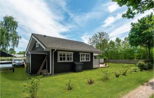una pequeña casa negra diminuta en un patio en Gorgeous Home In Sams With Kitchen, en Onsbjerg