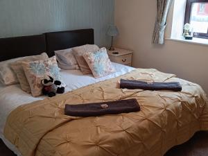a bed with two pillows on top of it at Cosy cottage in the heart of Pateley Bridge. in Pateley Bridge