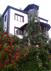 una casa blanca con flores delante en Nergis dağ evi, en Trabzon