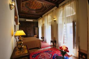 - une chambre avec un lit et une table avec une lampe dans l'établissement Riad du Ciel Marrakech, à Marrakech